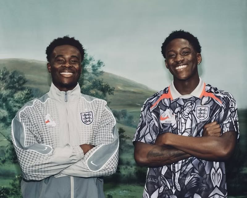 Two models in the Palace x Nike England collection, wearing the grey track top and the Pewter Grey jersey